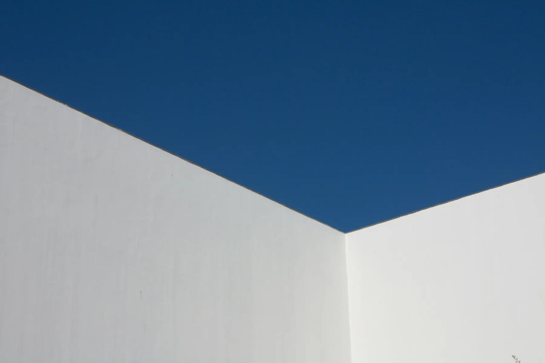 White building walls against a deep blue sky